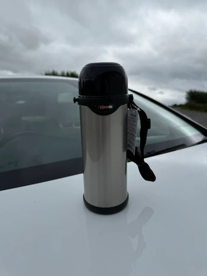 Portable Zojirushi SJ-S stainless steel thermos with strap, shown outdoors in Ireland
